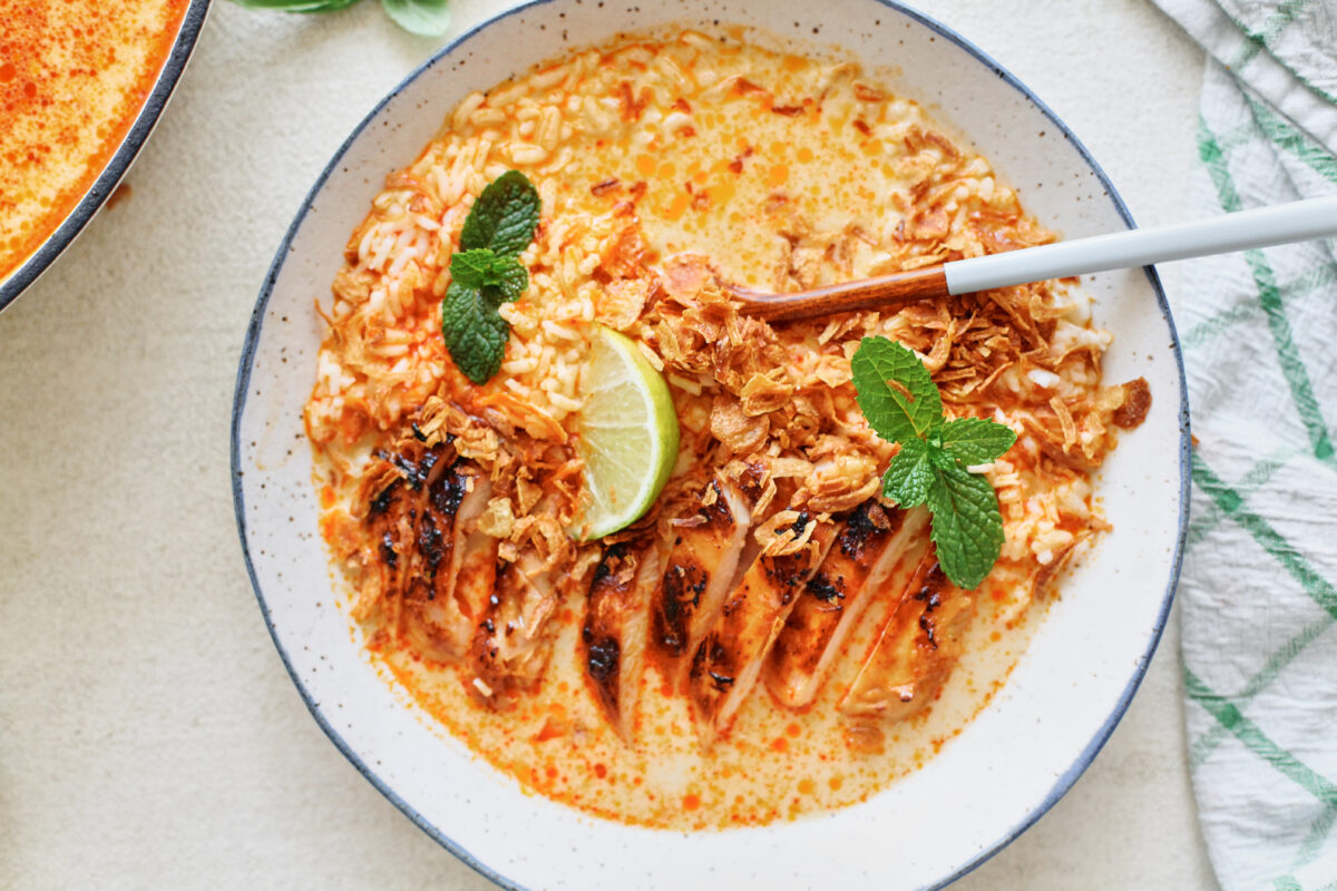 spicy yellow curry chicken & brothy rice bowl topped with crispy shallots, mint, and lime wedges