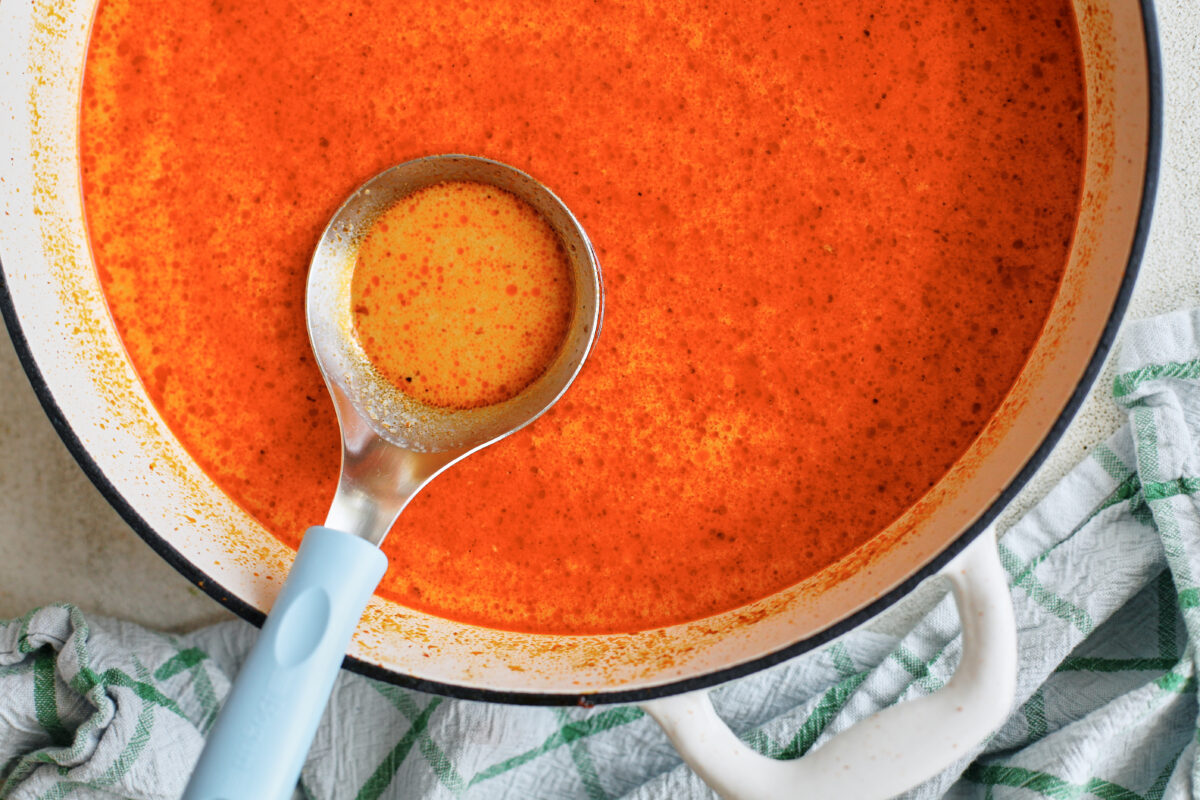 yellow curry broth in a large white skillet with a black rim