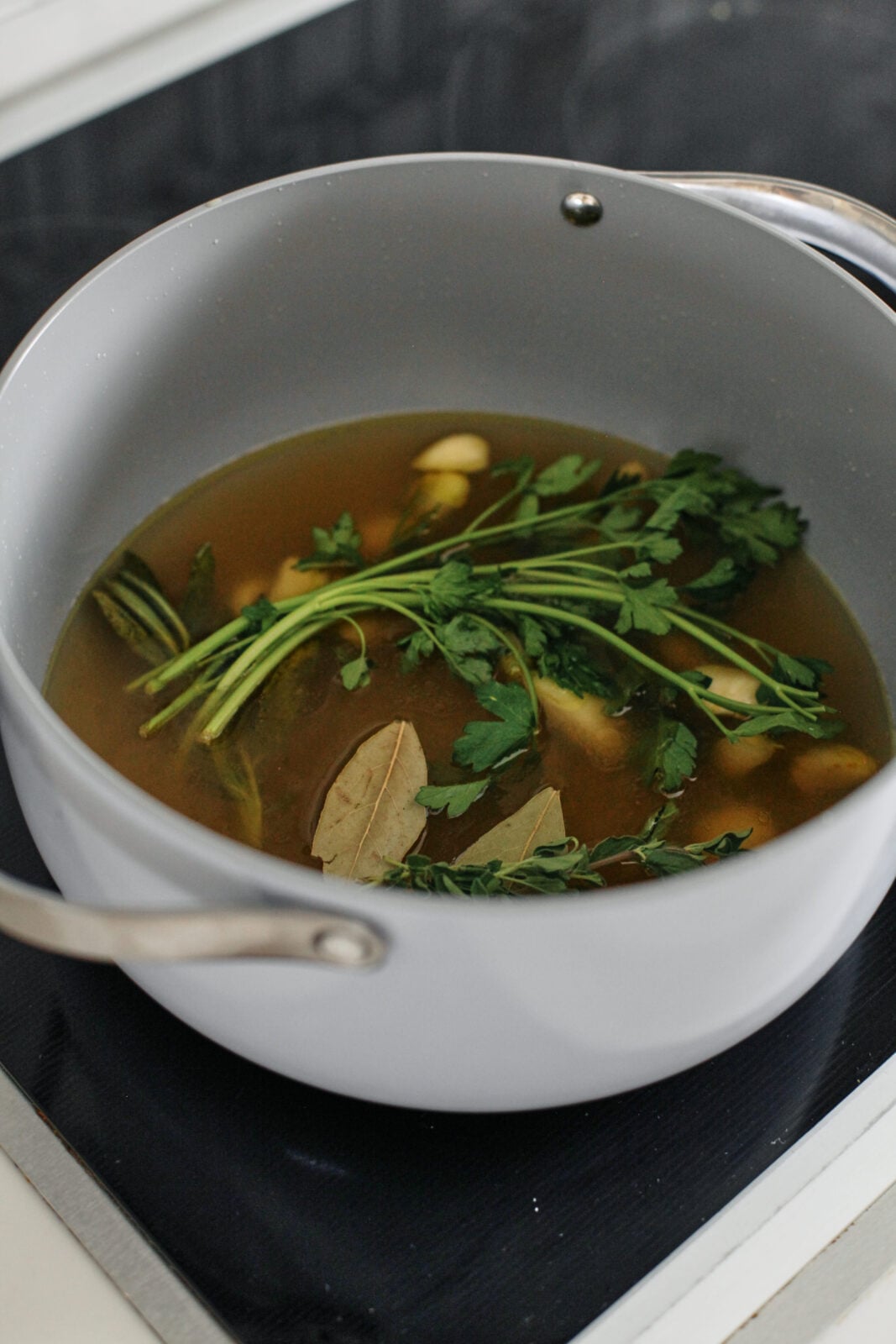 soup ingredients added to the olive oil, garlic, and sage: chicken broth, parsley, thyme, and bay leaves